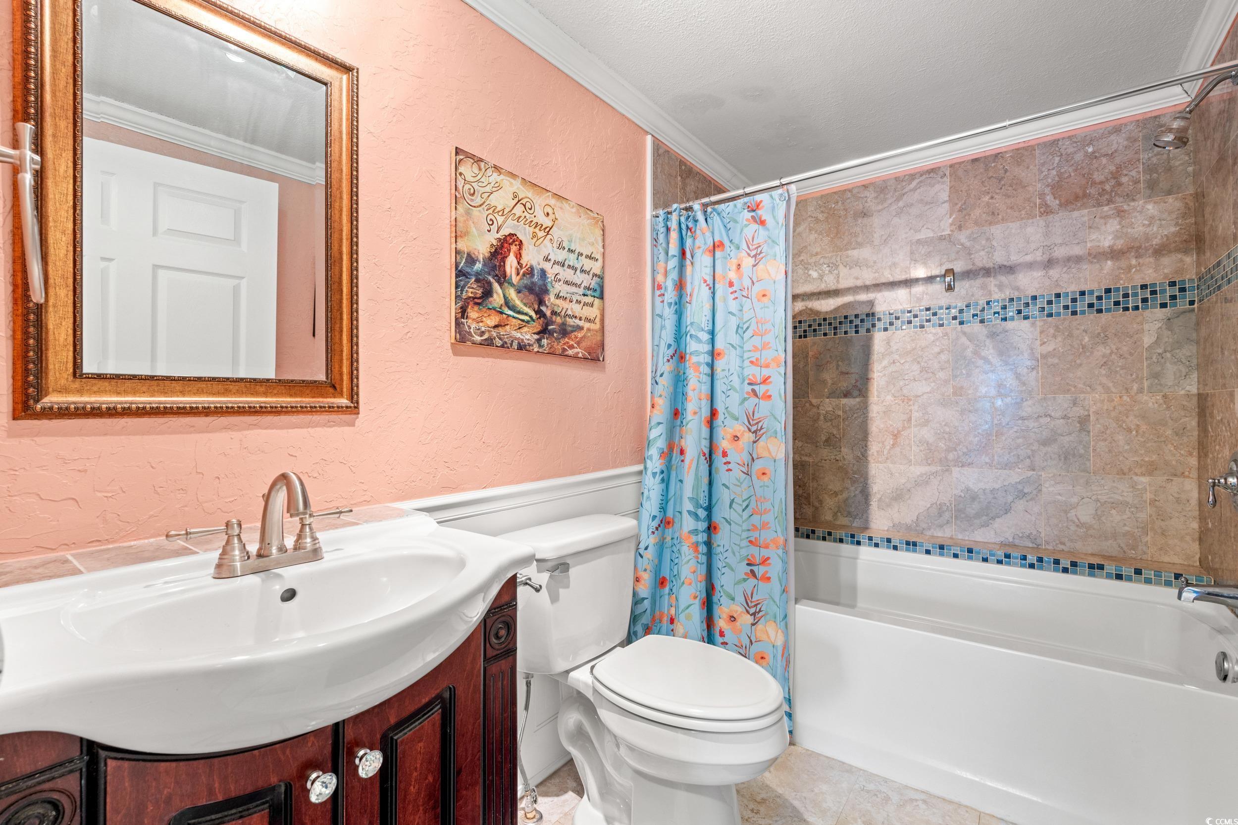 467 Freedom Circle Myrtle Beach, SC 29588 - Photo 21 of 38 Full bathroom featuring a textured wall, crown molding, vanity, and shower / bath combination with curtain