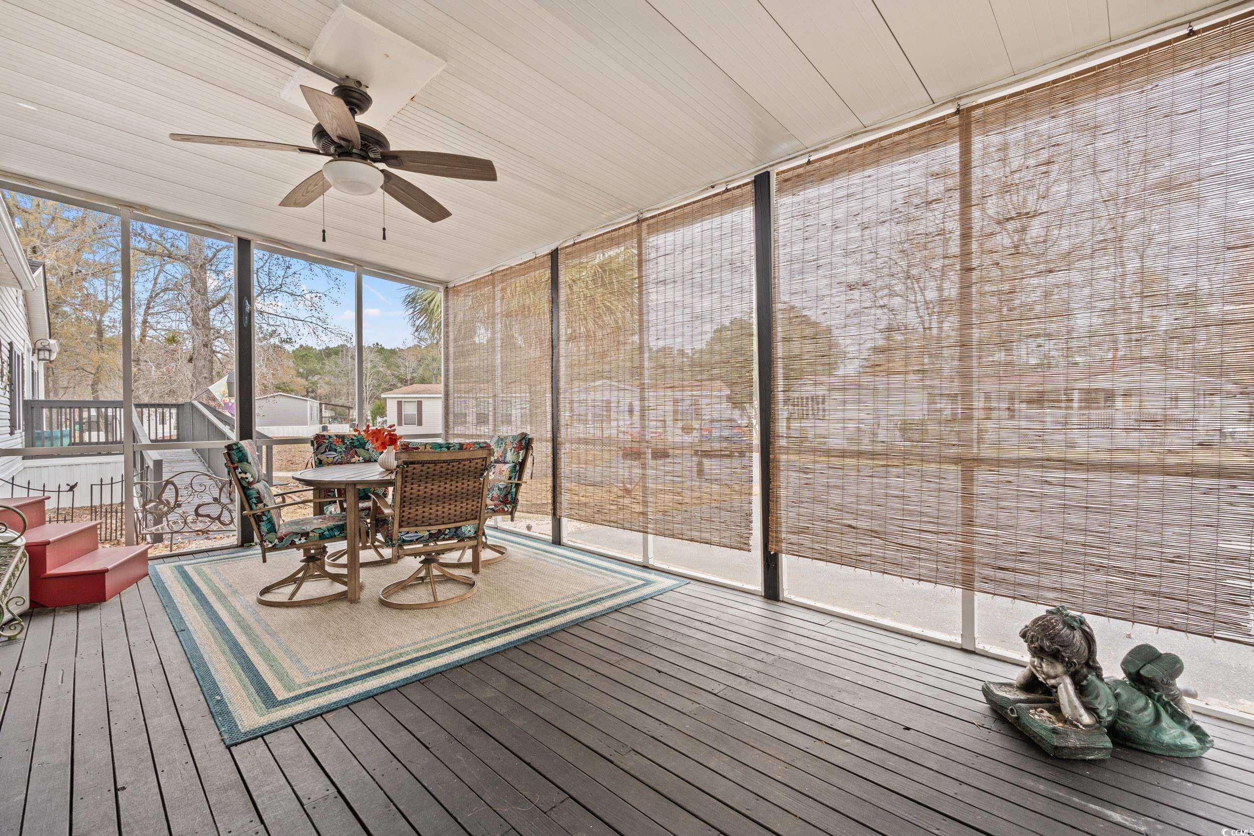 467 Freedom Circle Myrtle Beach, SC 29588 - Photo 25 of 38 Sunroom with ceiling fan and outdoor dining area