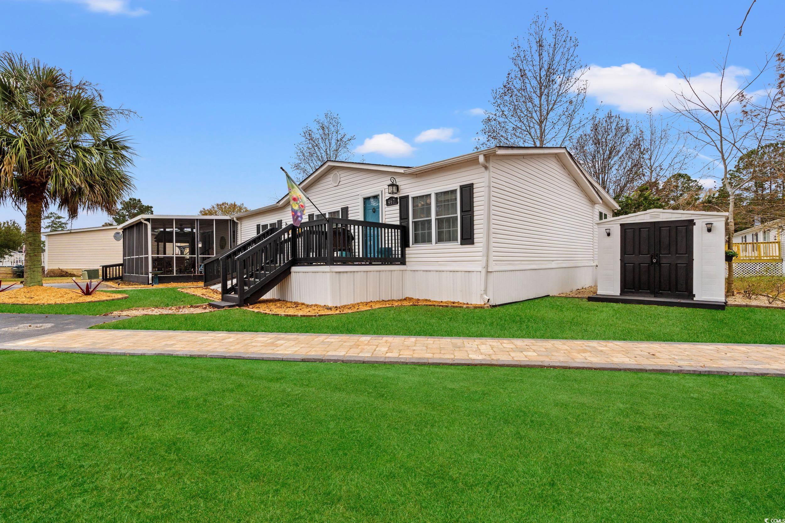 467 Freedom Circle Myrtle Beach, SC 29588 - Photo 28 of 38 View of front of house with a front yard, a wooden deck, a sunroom, a storage unit, and stairs