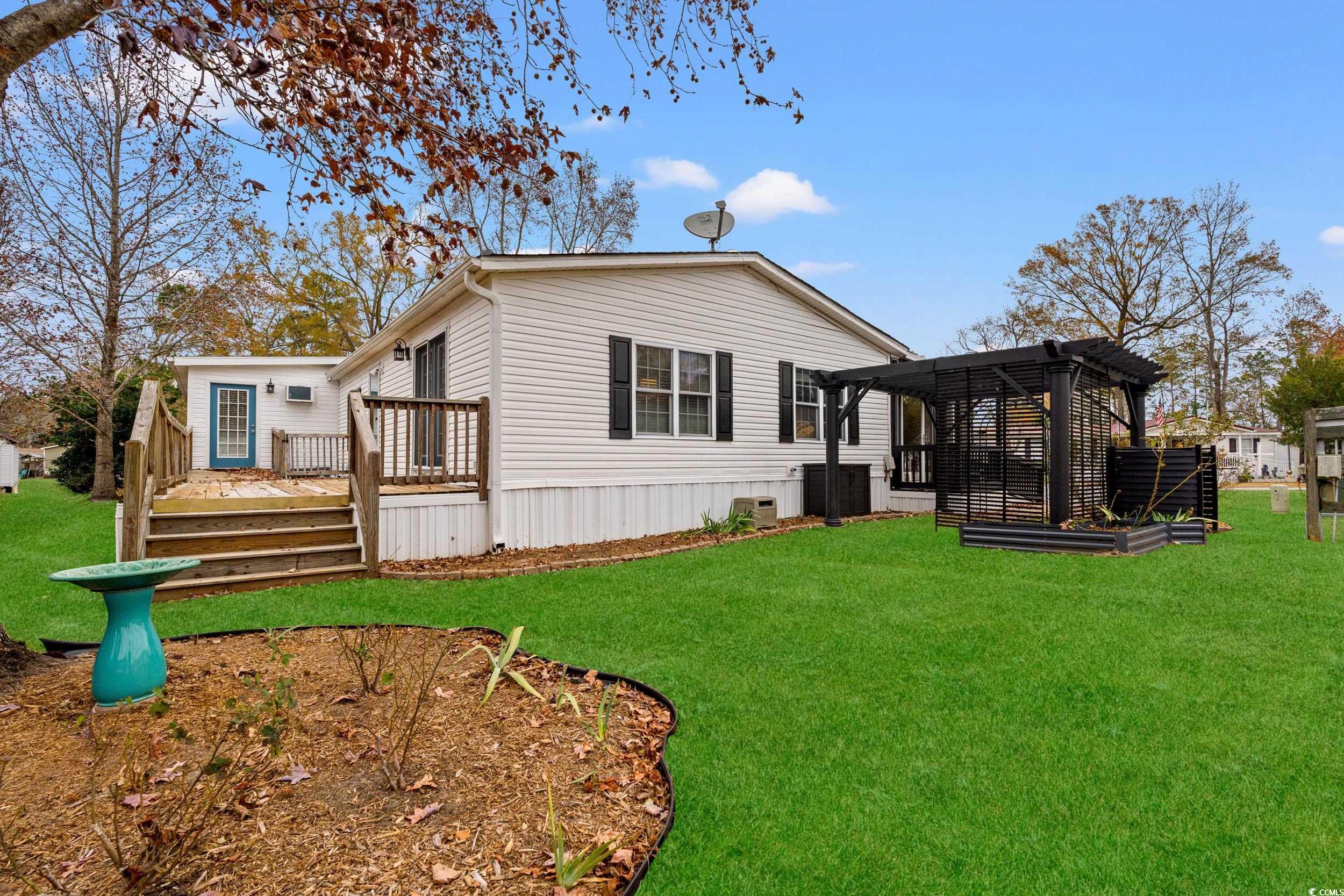 467 Freedom Circle Myrtle Beach, SC 29588 - Photo 30 of 38 View of property exterior featuring a wooden deck and a lawn