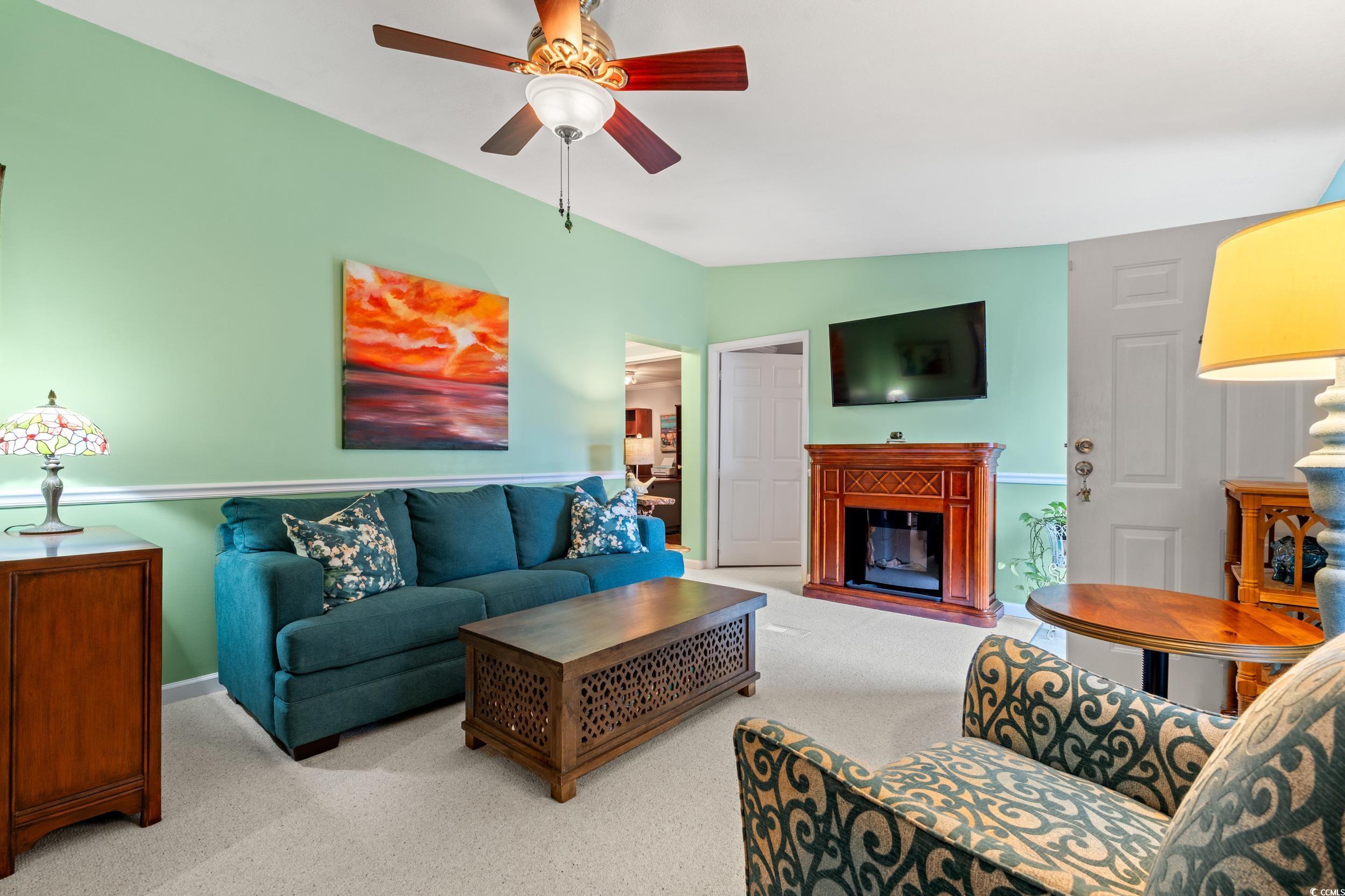 467 Freedom Circle Myrtle Beach, SC 29588 - Photo 7 of 38 Living area with a glass covered fireplace, carpet, ceiling fan, and lofted ceiling