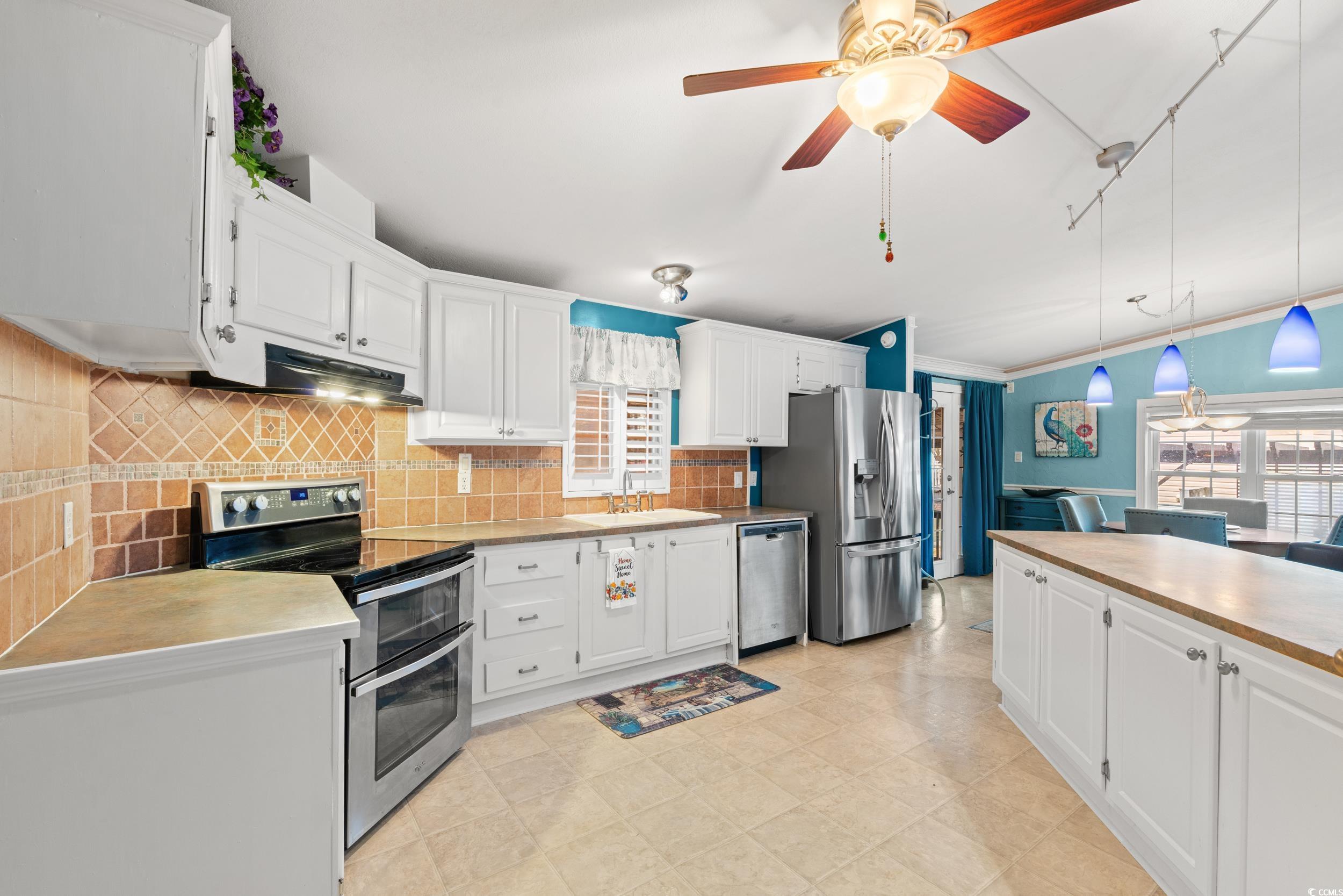 467 Freedom Circle Myrtle Beach, SC 29588 - Photo 9 of 38 Kitchen featuring appliances with stainless steel finishes, white cabinetry, pendant lighting, tasteful backsplash, and a ceiling fan