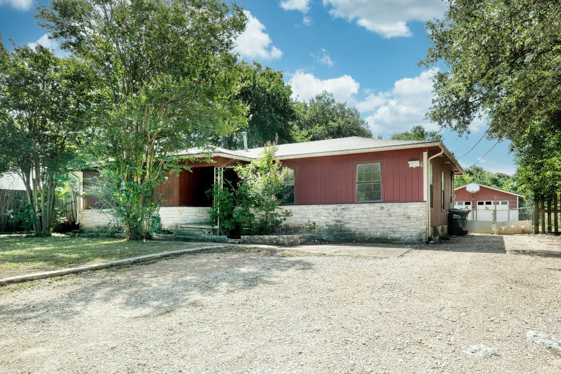 View of front facade featuring stone siding and driveway
