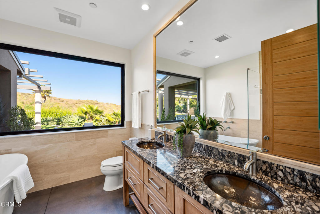 5572 Rainier Street Ventura, CA 93003 - Photo 12 of 29 a bathroom with a granite countertop sink a large mirror and a toilet