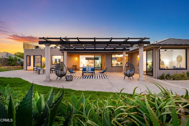 a view of a backyard with table and chairs with a barbeque grill and plants