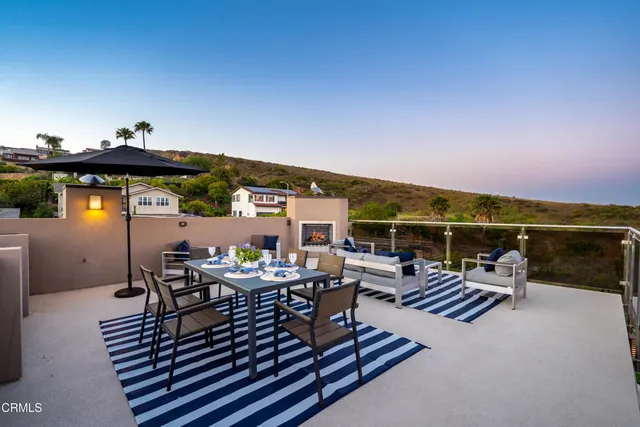 a roof deck with dining table and chairs