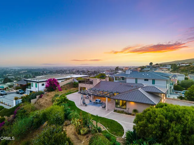 an aerial view of residential houses with outdoor space and trees