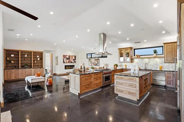 a kitchen with stainless steel appliances kitchen island granite countertop a sink and cabinets