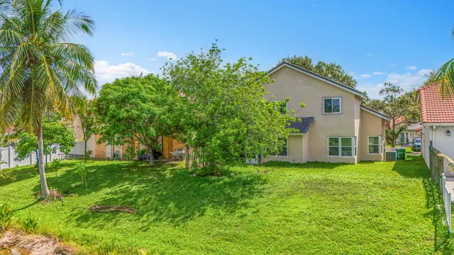 a white house with a small yard and trees