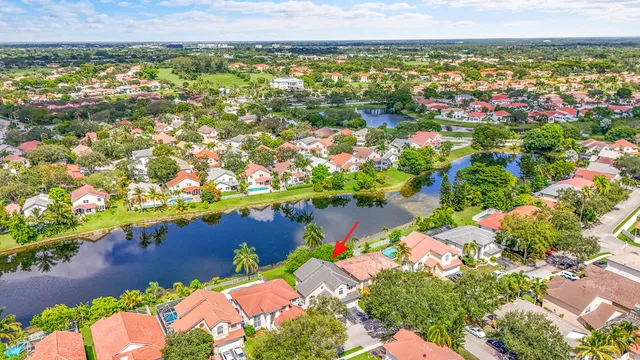 an aerial view of city and lake with trees