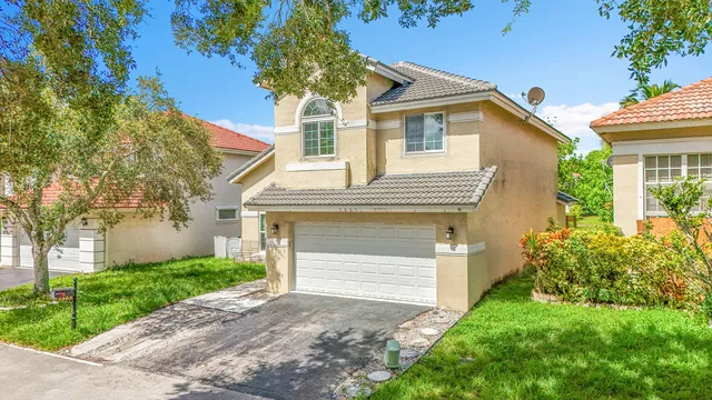 a front view of a house with a yard and trees