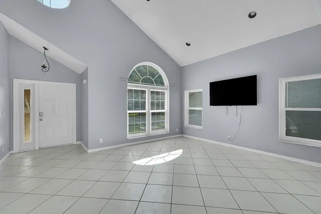 a view of an empty room with a window and a flat screen tv