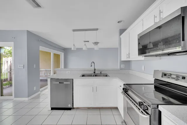 a kitchen with stainless steel appliances granite countertop a sink and a stove