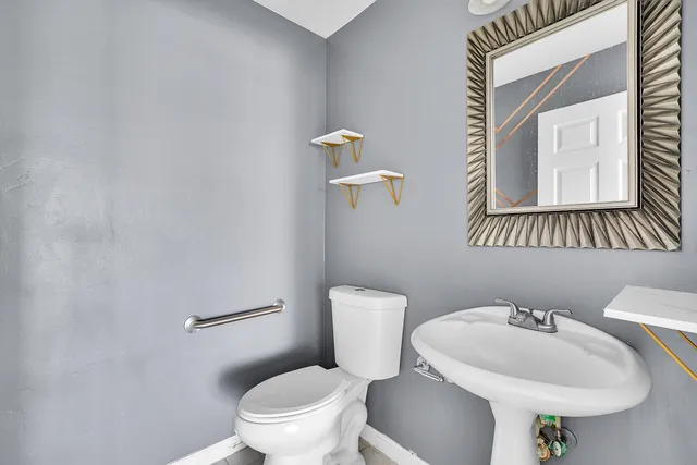 a bathroom with a toilet a sink and mirror