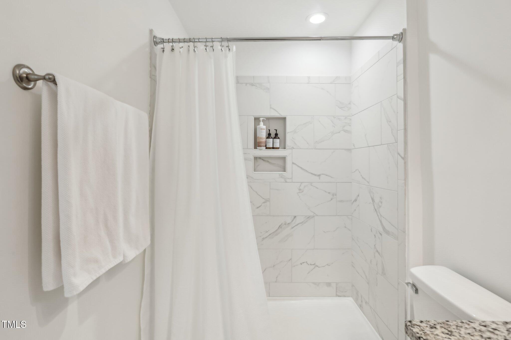 5902 Carmel Lane Raleigh, NC 27609 - Photo 17 of 37 a bathroom with a shower and a toilet