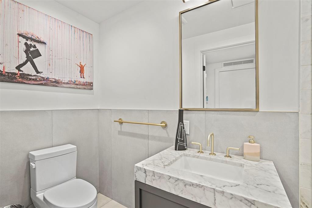 70 Rainey Street, Unit 1409 Austin, TX 78701 - Photo 19 of 38 Half bath featuring vanity and a wainscoted wall