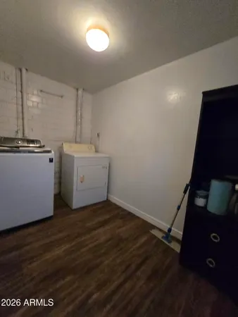 a view of a kitchen with fridge and wooden floor