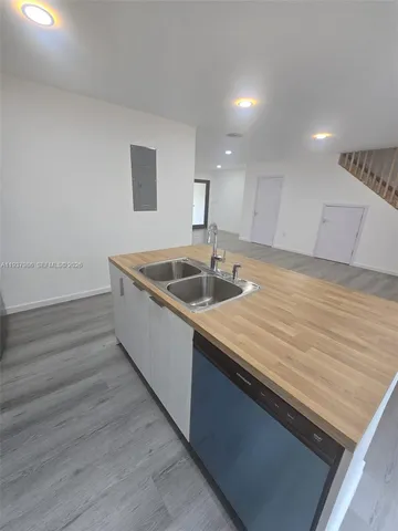 a kitchen with kitchen island a sink and wooden floor