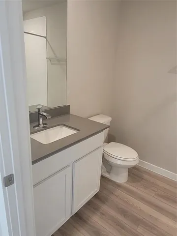 a bathroom with a granite countertop toilet and sink