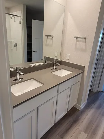 a bathroom with a double vanity sink and mirror