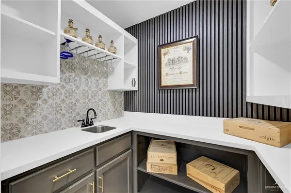 a kitchen with stainless steel appliances granite countertop a sink a stove a refrigerator and white cabinets with wooden floor