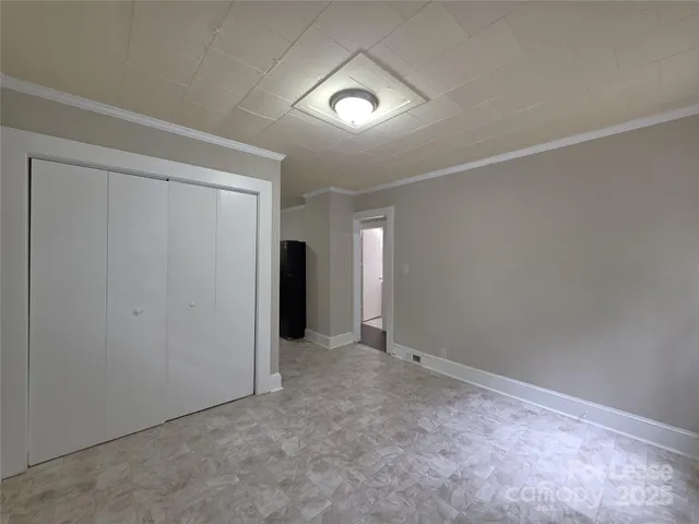 an empty room with closet and mirror