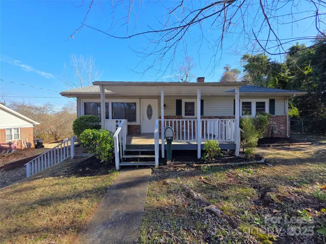 a view of a house with a yard and sitting area