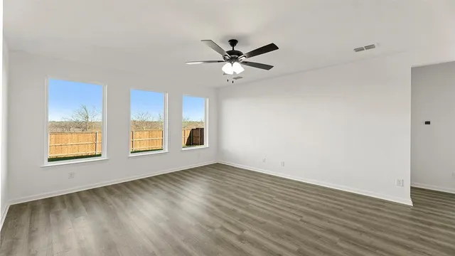 a view of a kitchen with wooden floor and a ceiling fan