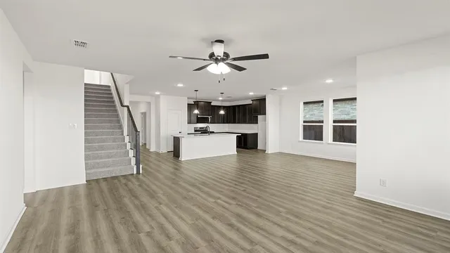 an empty room with window and ceiling fan