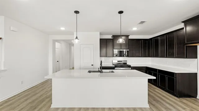 a view of a kitchen with a sink stainless steel appliances and cabinets