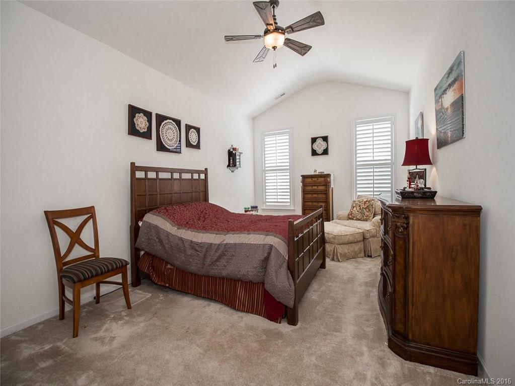 219 Garnet Court, Unit 558 Fort Mill, SC 29708 - Photo 13 of 23 a spacious bedroom with a bed a dresser and painting