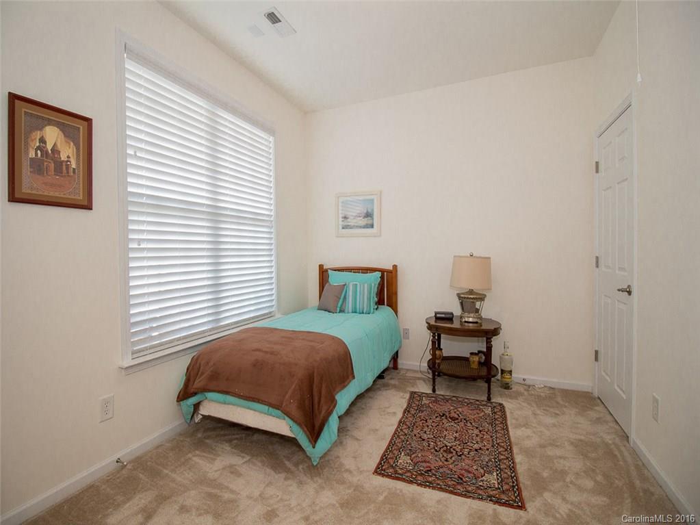 219 Garnet Court, Unit 558 Fort Mill, SC 29708 - Photo 17 of 23 a bedroom with a bed lamp and a potted plant