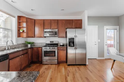 a kitchen with stainless steel appliances granite countertop a refrigerator a stove top oven a sink and dishwasher