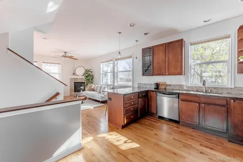 a large kitchen with stainless steel appliances granite countertop a large window a sink and a counter space