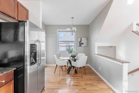 a dining room with furniture a chandelier and wooden floor