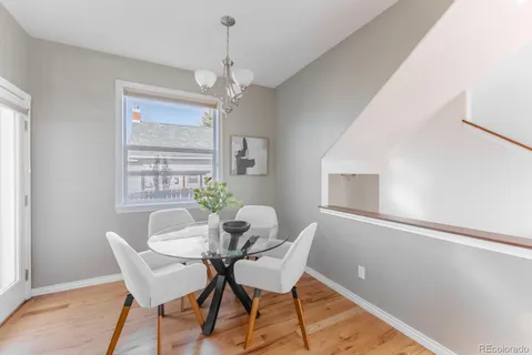 a dining room with furniture a chandelier and wooden floor