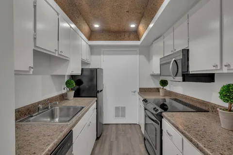 a kitchen with stainless steel appliances granite countertop a sink a stove and a refrigerator
