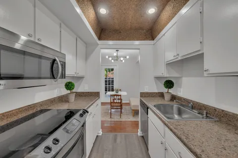 a kitchen with granite countertop a sink stainless steel appliances and cabinets