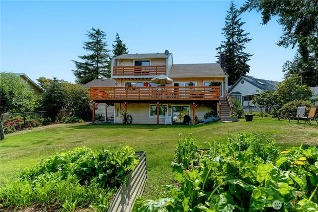 a view of a house with a big yard plants and large trees