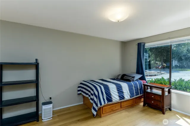 a bedroom with a bed and a dresser next to a window