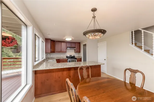 a dining room with wooden floor a chandelier a wooden table and chairs