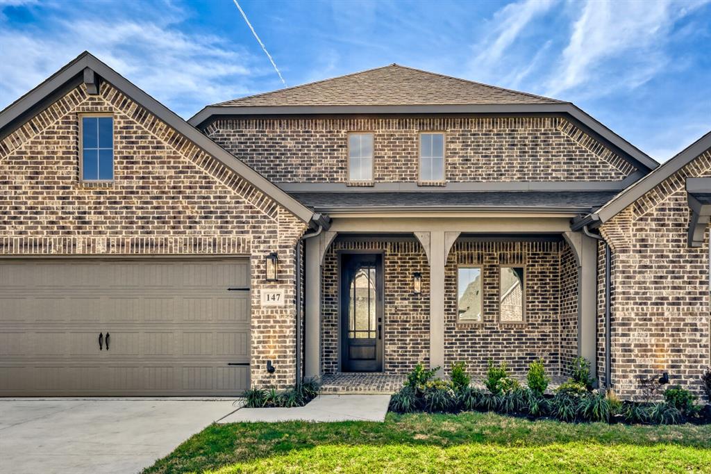 147 Derrett Lane Rhome, TX 76078 - Photo 26 of 28 View of front of home featuring covered porch, brick siding, concrete driveway, roof with shingles, and an attached garage