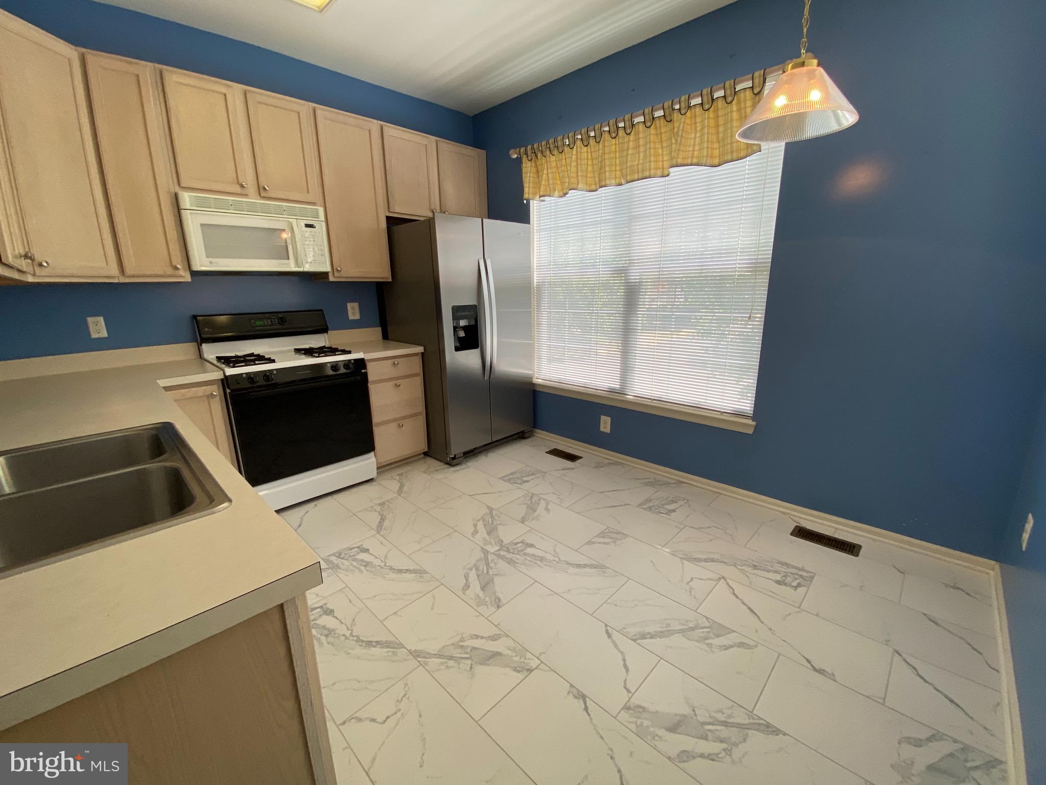 4110 Flower Fairfax, VA 22030 - Photo 4 of 64 a kitchen with a refrigerator a stove a microwave and cabinets