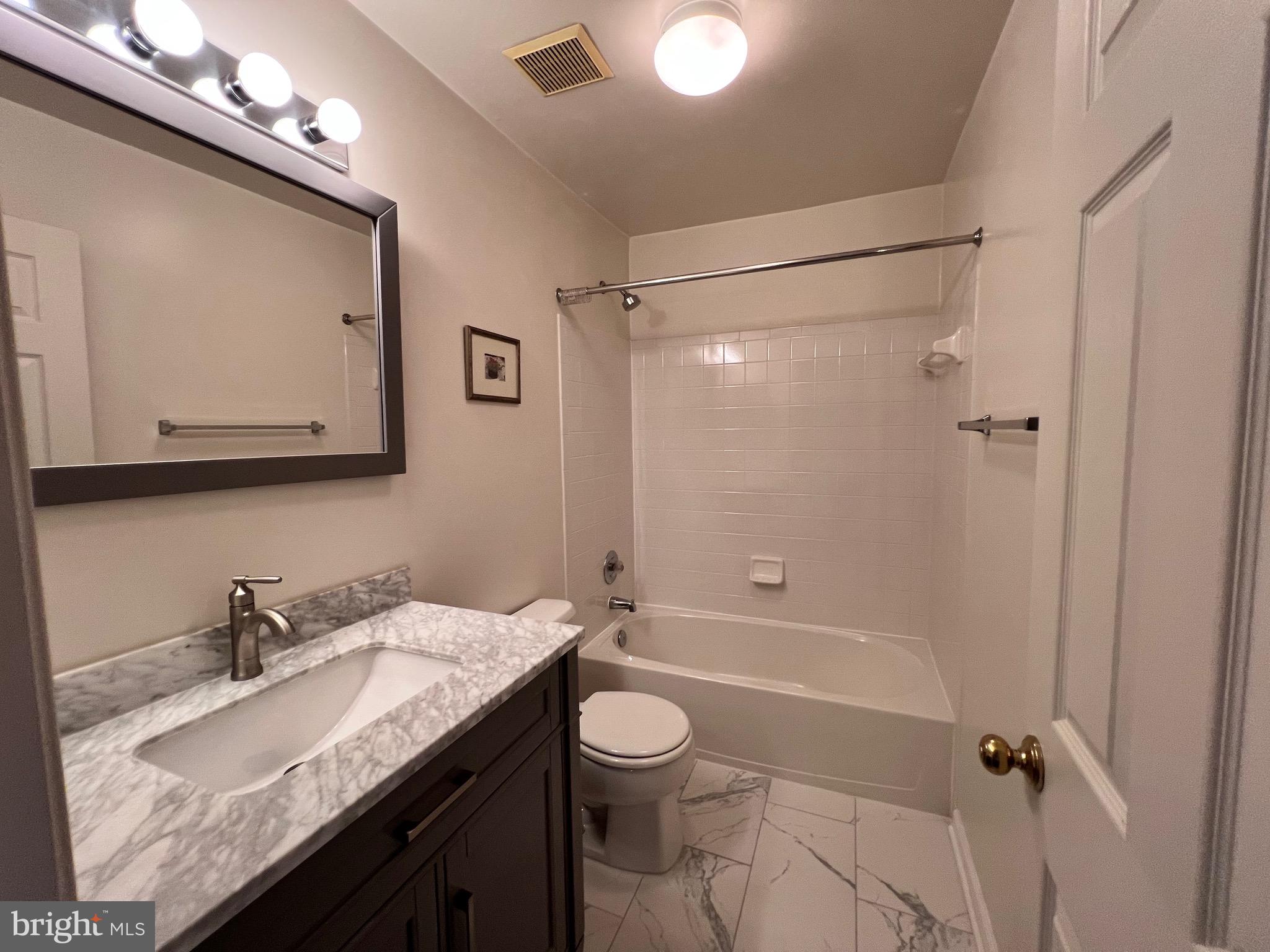 4110 Flower Fairfax, VA 22030 - Photo 48 of 64 a bathroom with a granite countertop sink toilet a mirror and shower