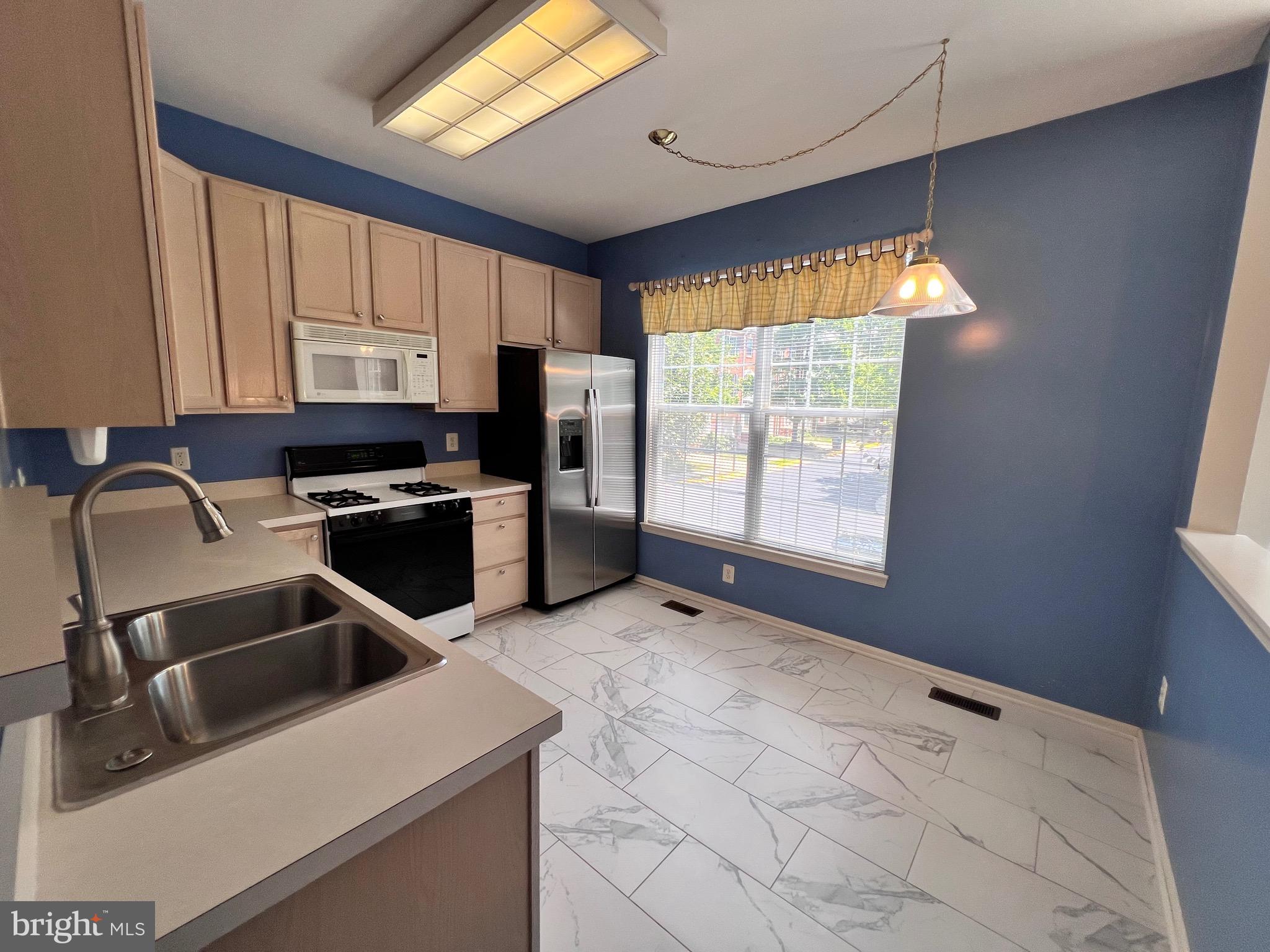 4110 Flower Fairfax, VA 22030 - Photo 56 of 64 a kitchen with stainless steel appliances a stove a sink a microwave a refrigerator and cabinets