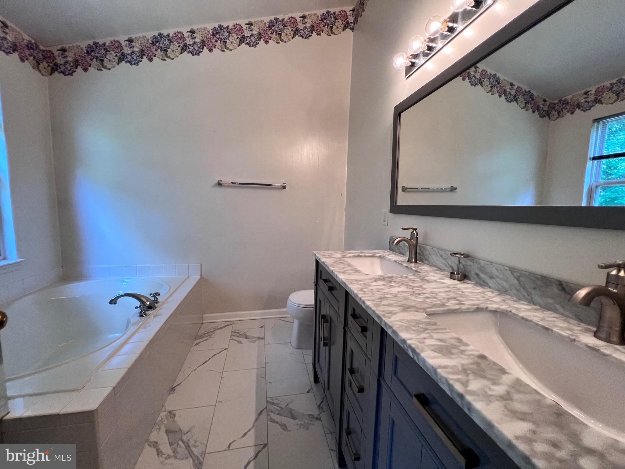 4110 Flower Fairfax, VA 22030 - Photo 6 of 64 a bathroom with a granite countertop sink a mirror a vanity and bathtub