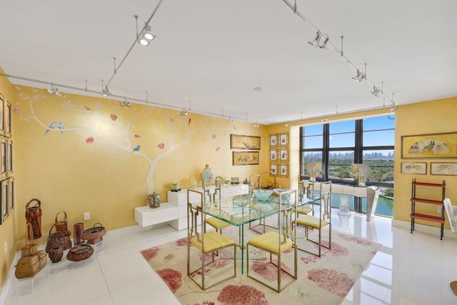 a living room with furniture a flat screen tv and floor to ceiling window