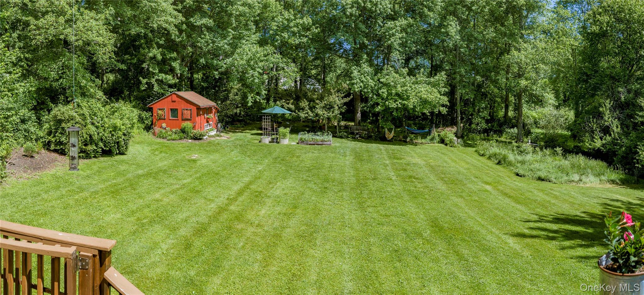 32 Cobb Road Brewster, NY 10509 - Photo 4 of 49 a backyard of a house with plants and large trees