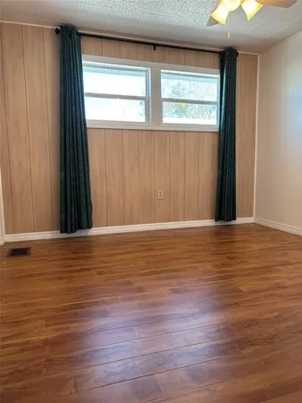 a view of a room with wooden floor and a window