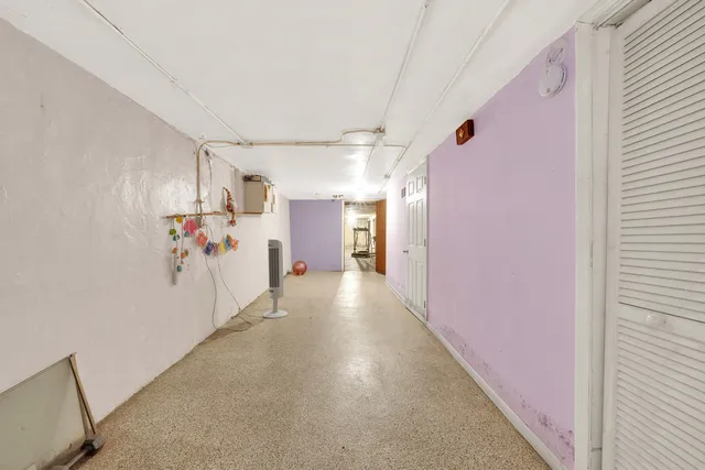 a view of an empty room with closet and entryway